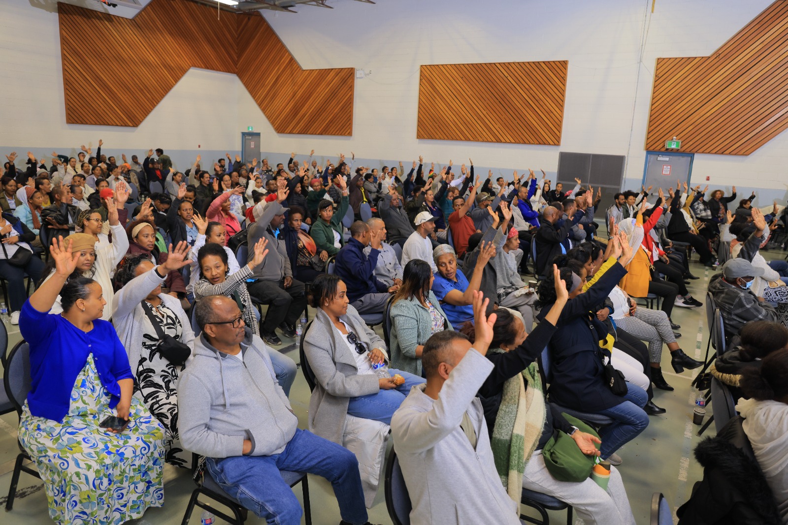 Members raise their hands during a vote